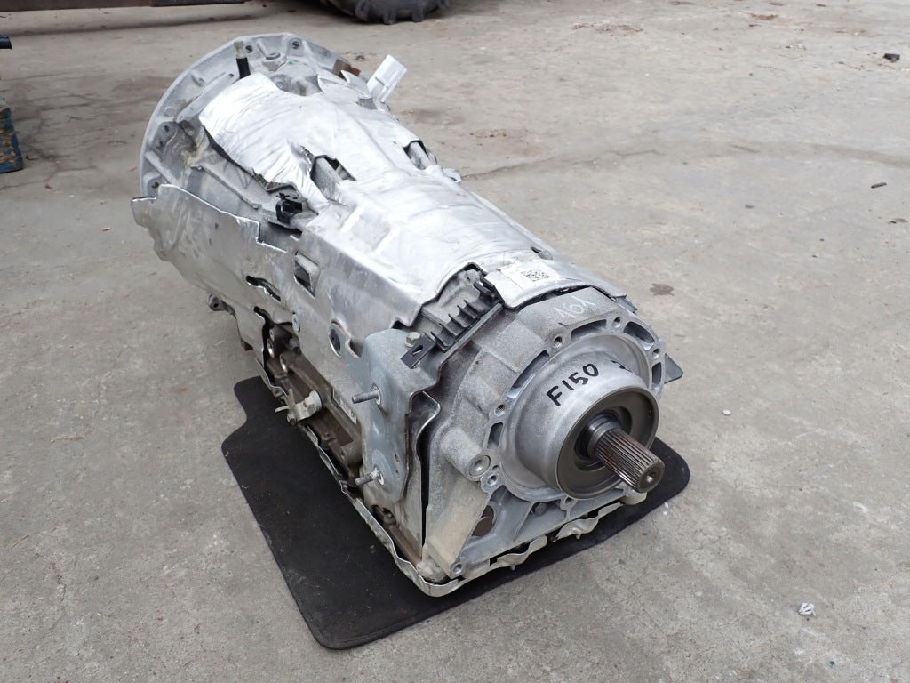 Skrzynia z kompletem silnika elektrycznego Ford F150 3.5 Powerboost Hybrid 2025, widoczna na zdjęciu, część układu napędowego.